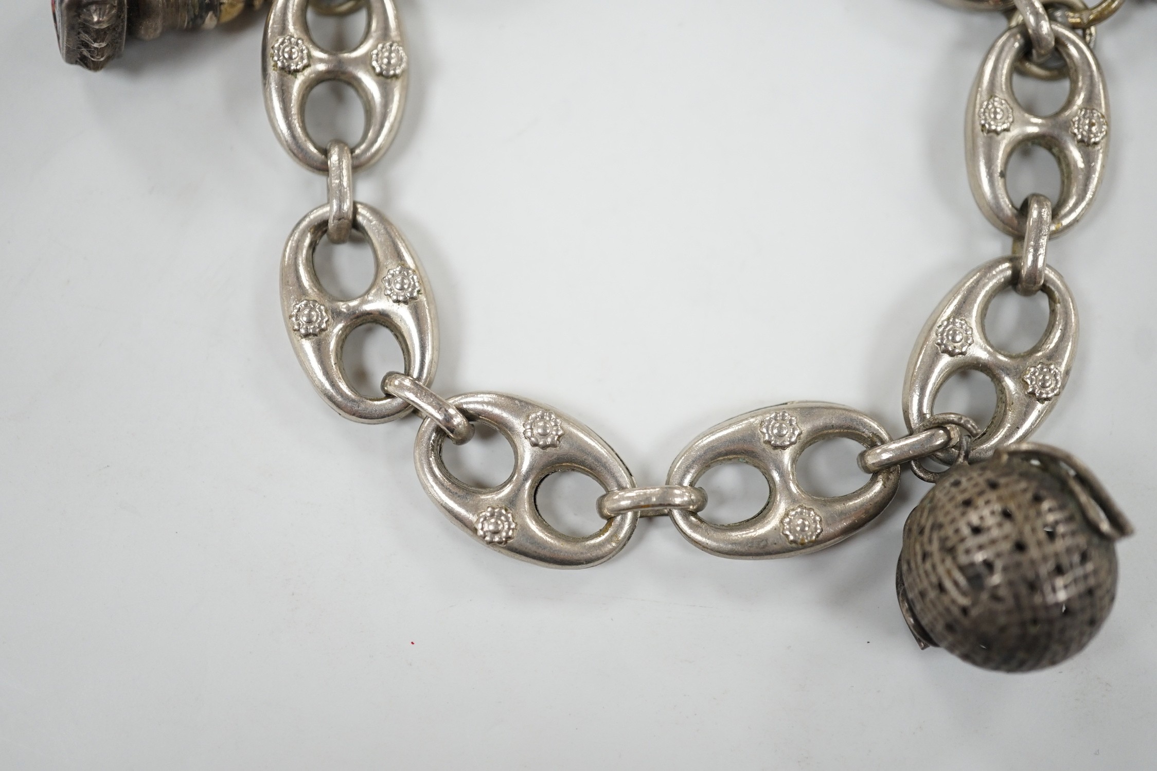 A white metal oval link bracelet, hung with three charms, including two fob seals, 21cm.